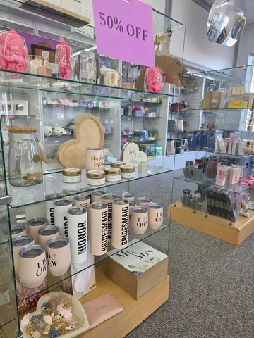 Glass display case of bridal party tumblers, candles and Mr & Mrs gifts